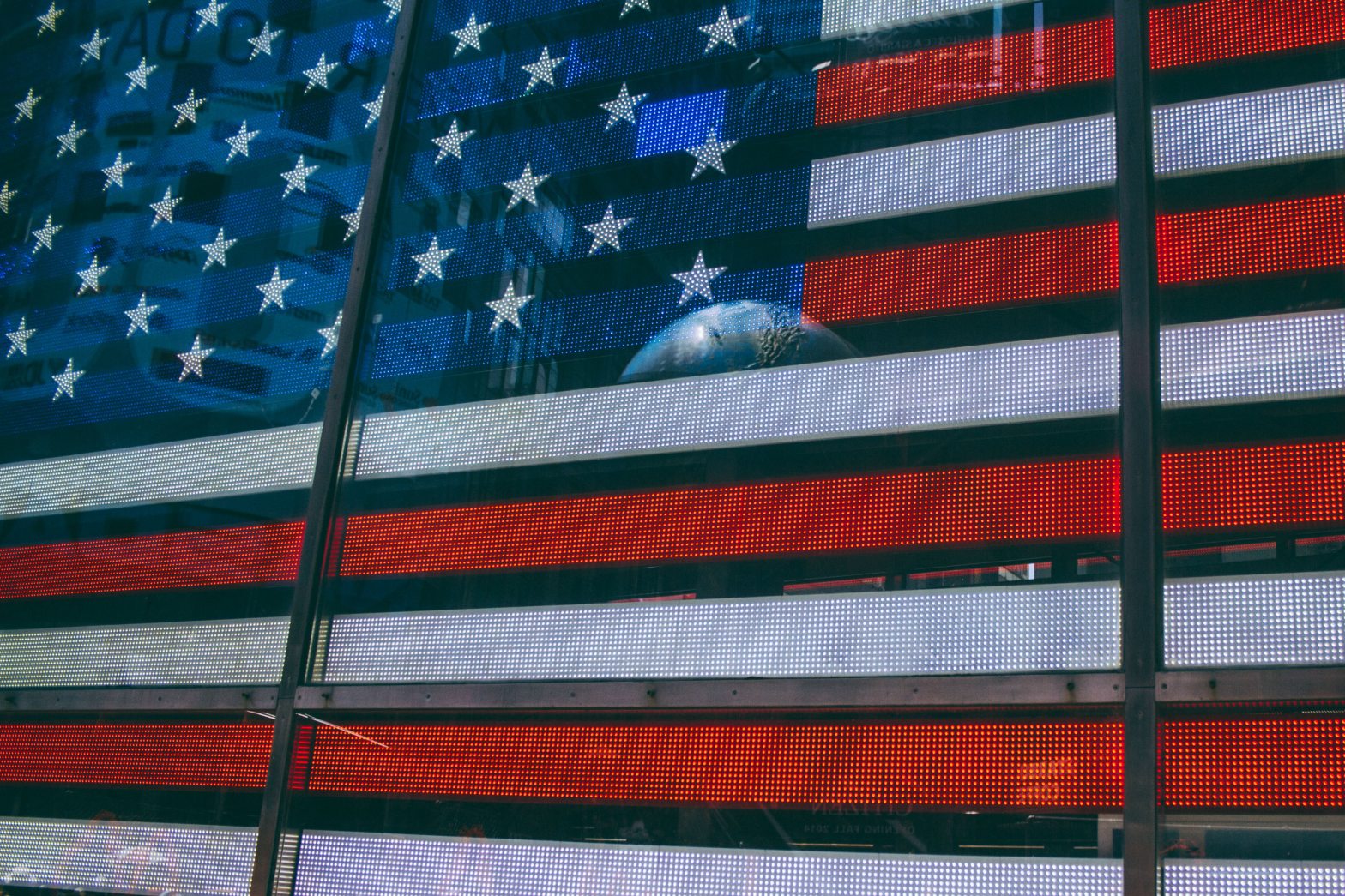 The image of planet Earth reflects in an a digital image of the American flag.